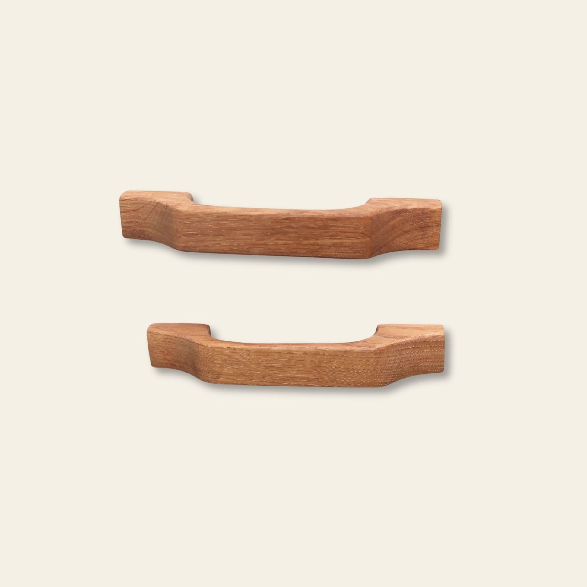 Two wooden cabinet handles on a beige background