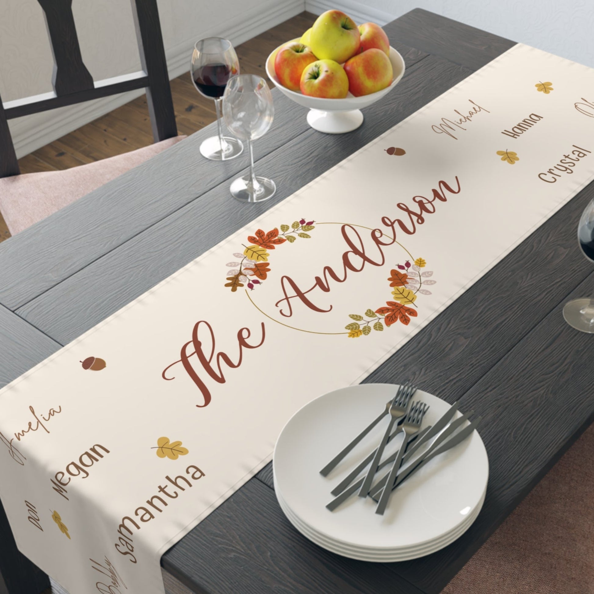 Dining table with a personalized fall-themed table runner featuring the name 'The Anderson'.