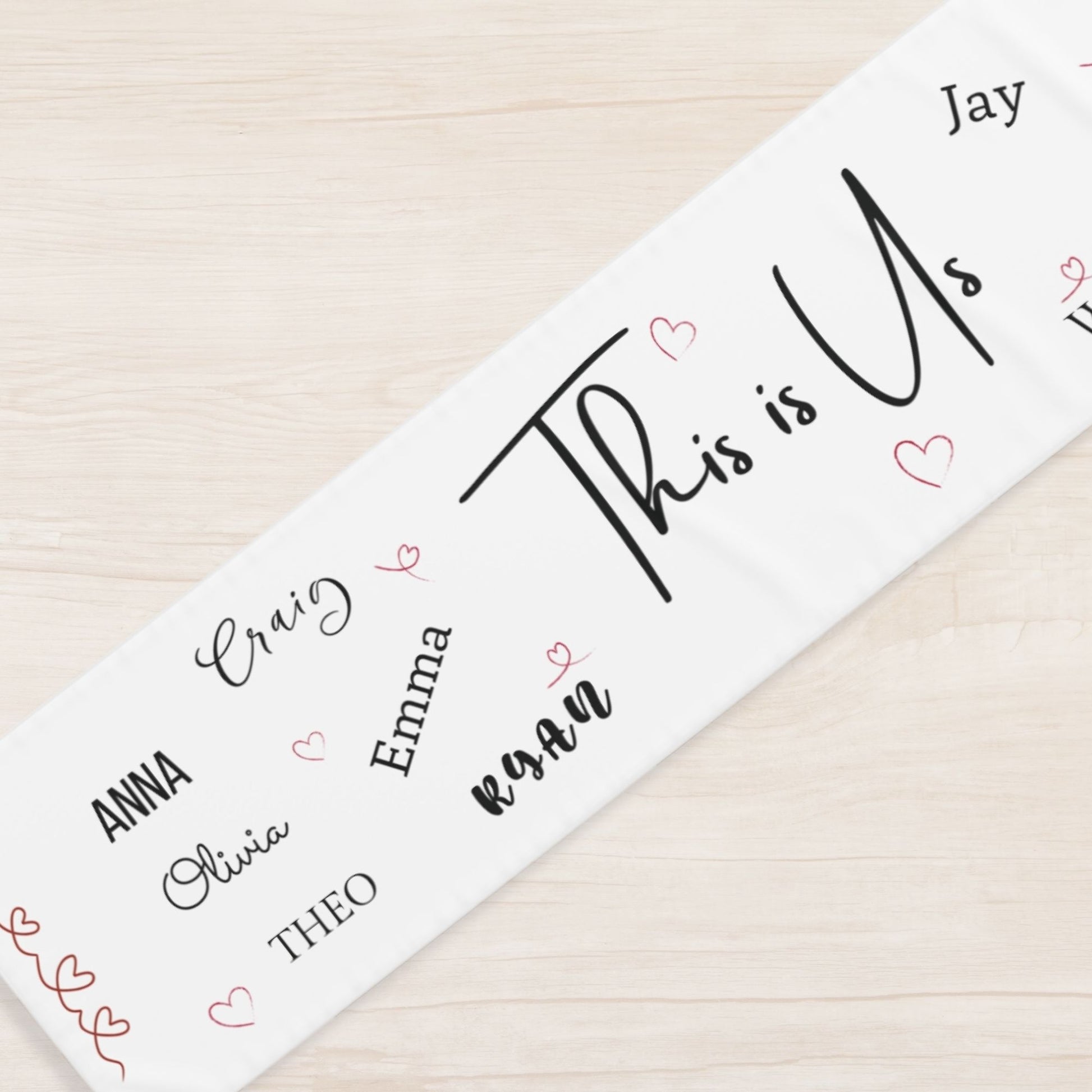 Personalized name runner with hearts on a wooden surface