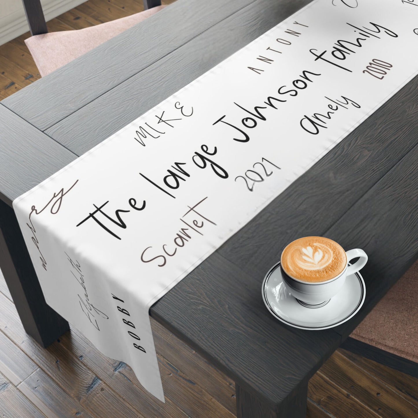 Personalized table runner with family names in a minimalist design.