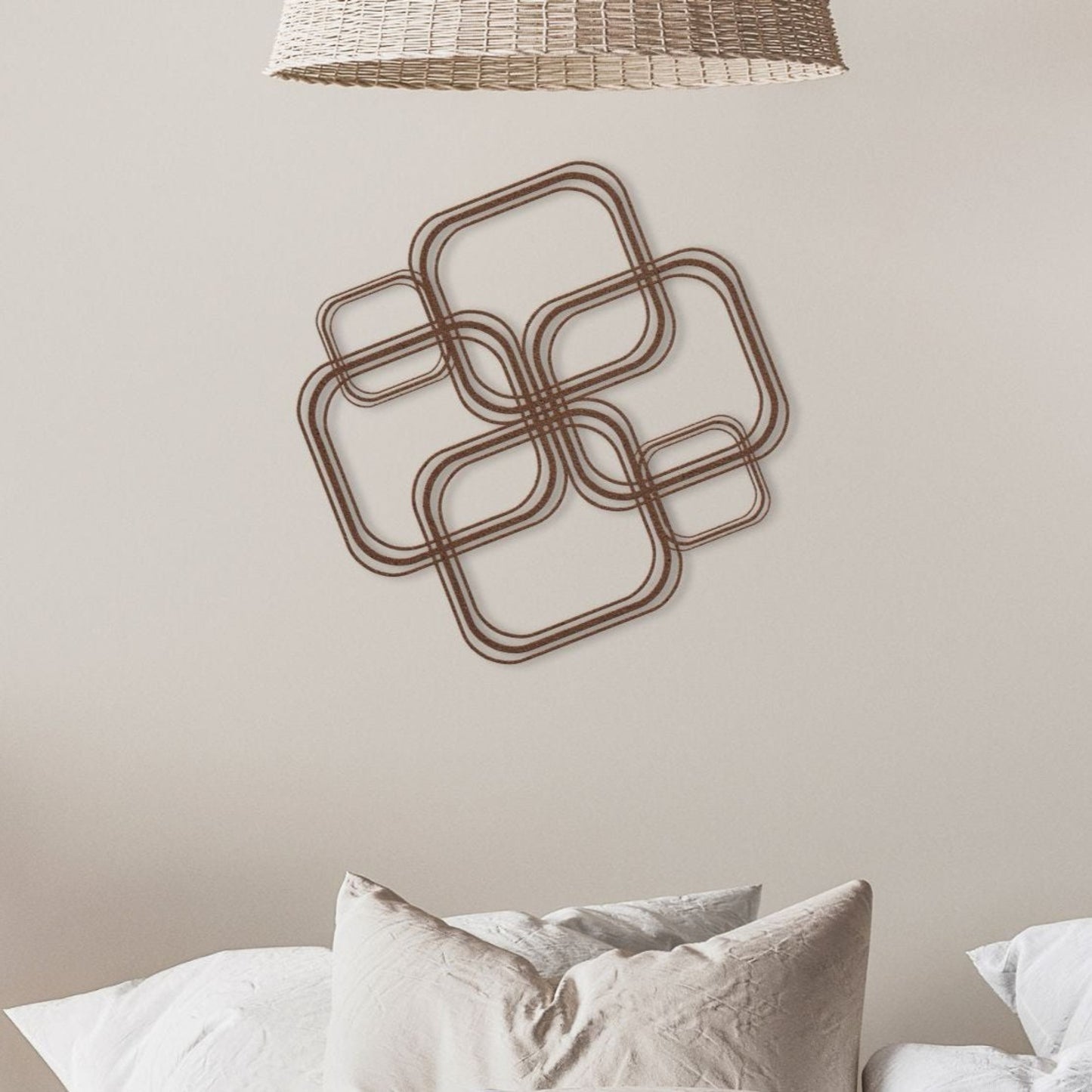 metal wall art with interlocking shapes on a neutral wall above a bed.