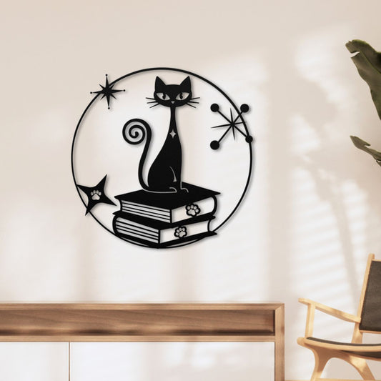 Decorative wall art of a black cat on books with starburst designs on a beige wall.