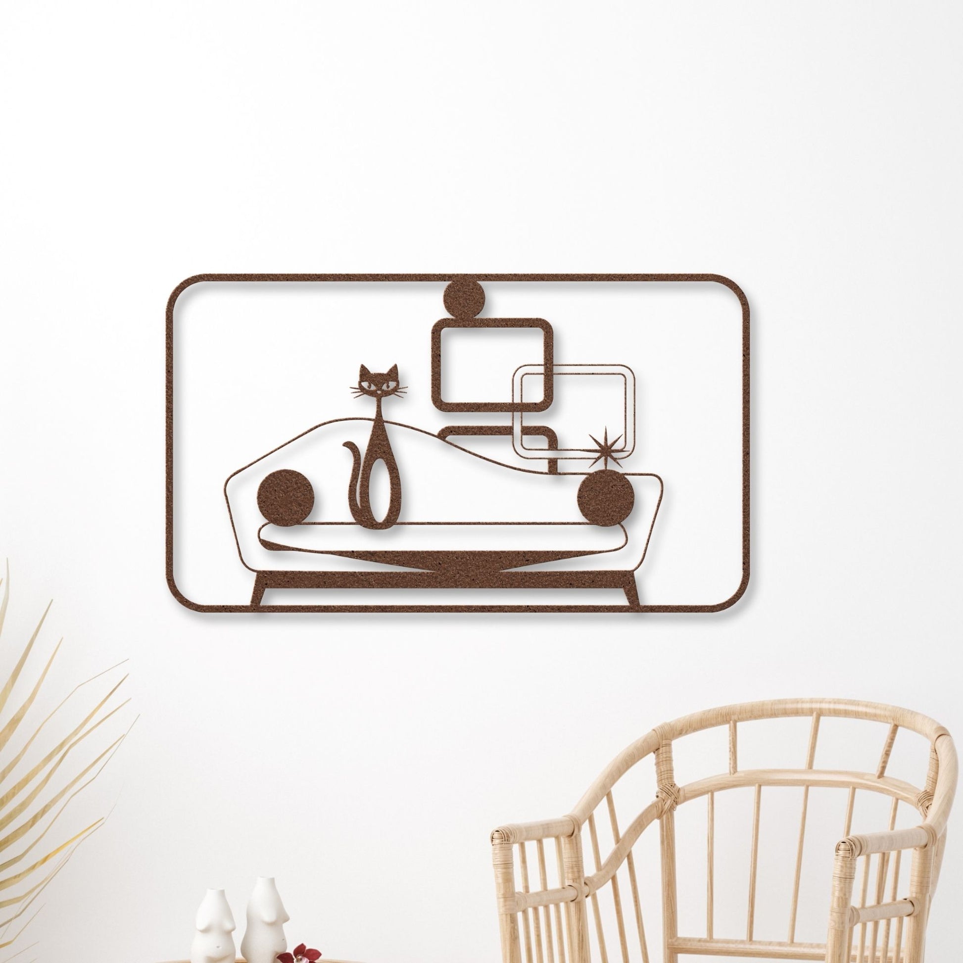 Decorative wall art with a cat and sofa design on a white wall.