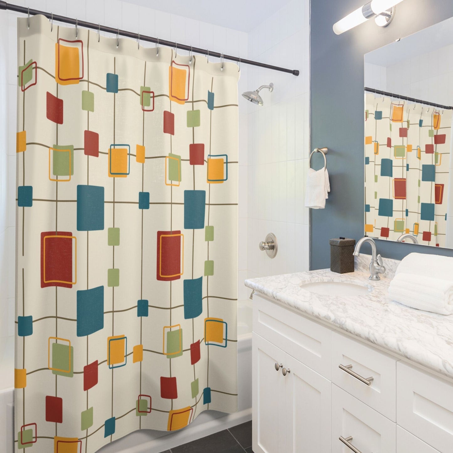 Mid-century modern shower curtain with colorful squares and rectangles on a cream background hanging in a bright bathroom.