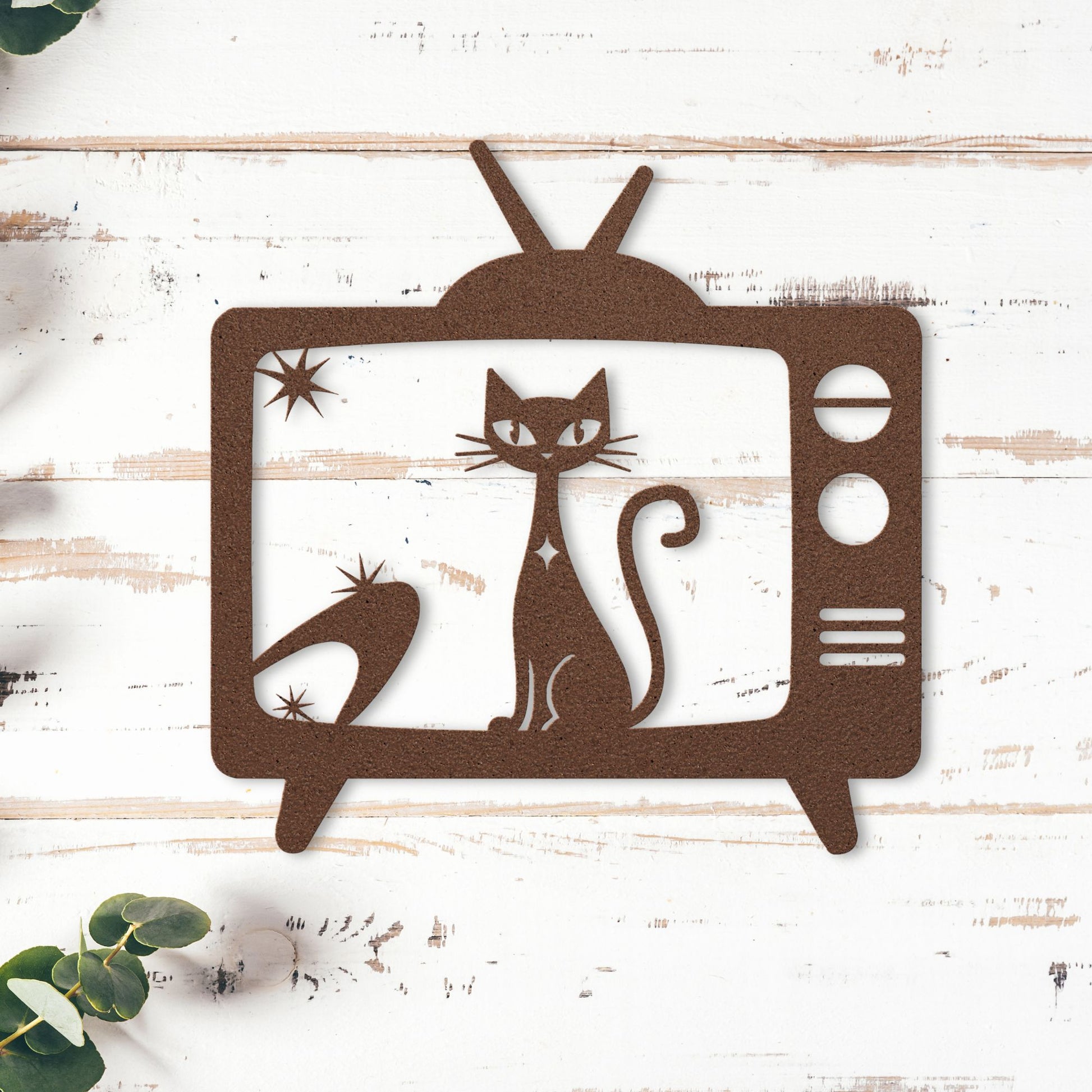 Mid-century modern wall accent of a cat inside an old-fashioned television set on a wooden surface.