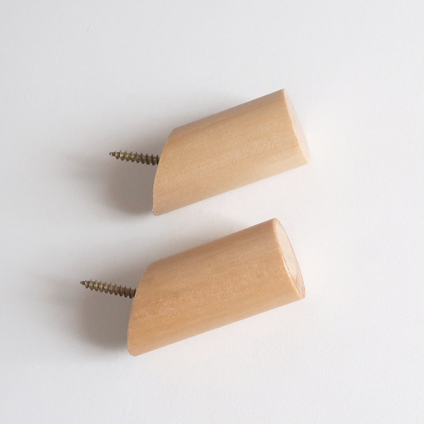 Two light natural wood cylindrical wall hooks