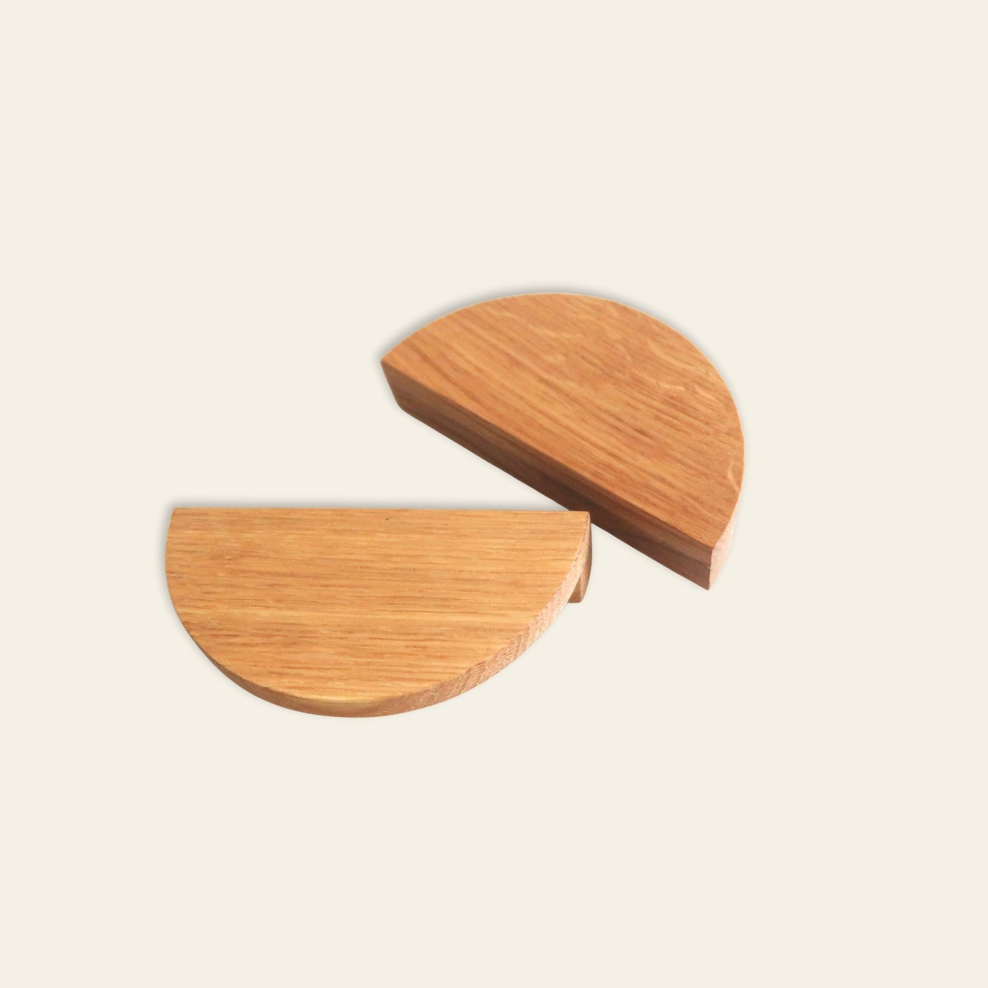 Two wooden half-circle handles on a light beige background