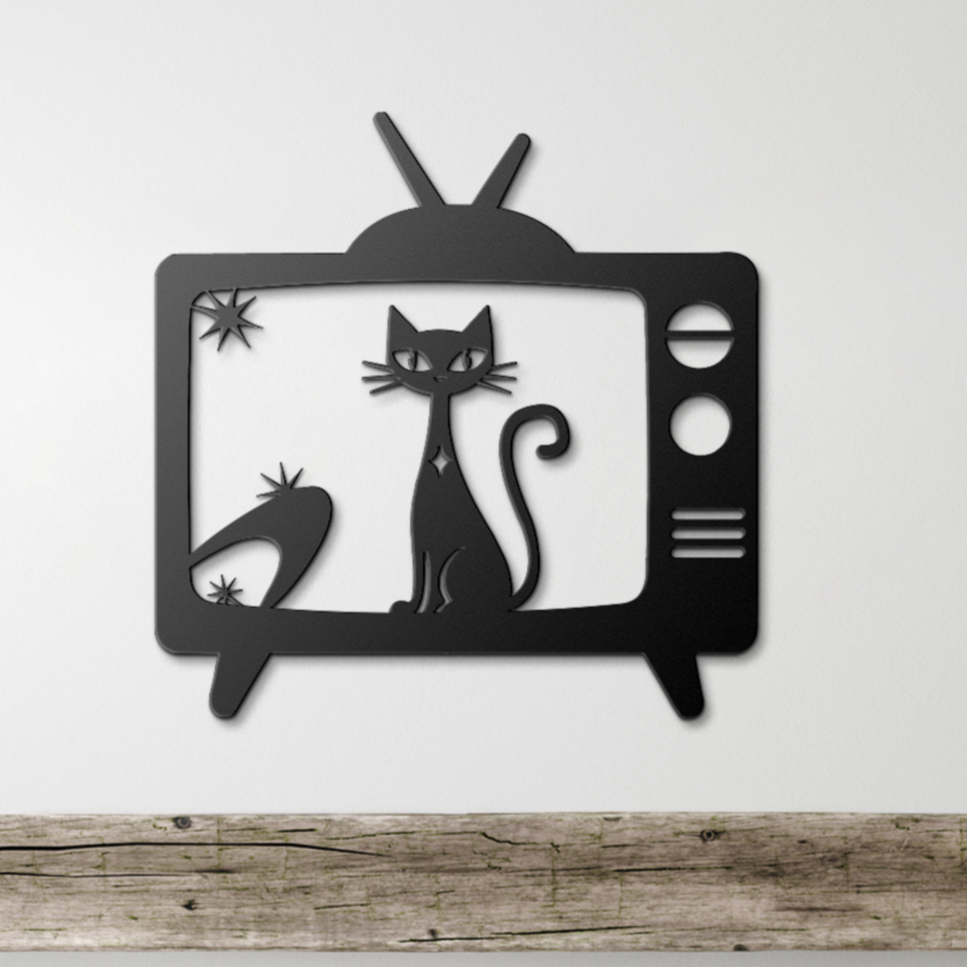 Black metal wall decor of a vintage television featuring a stylized cat and boomerang motif