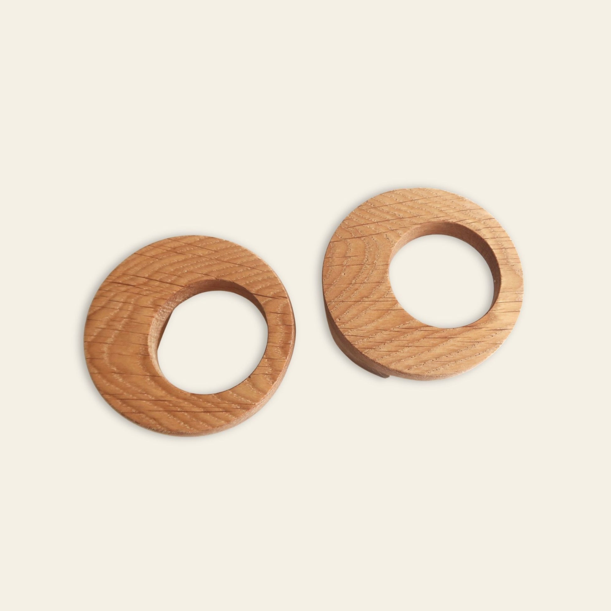 Two wooden cabinet handles on a beige background
