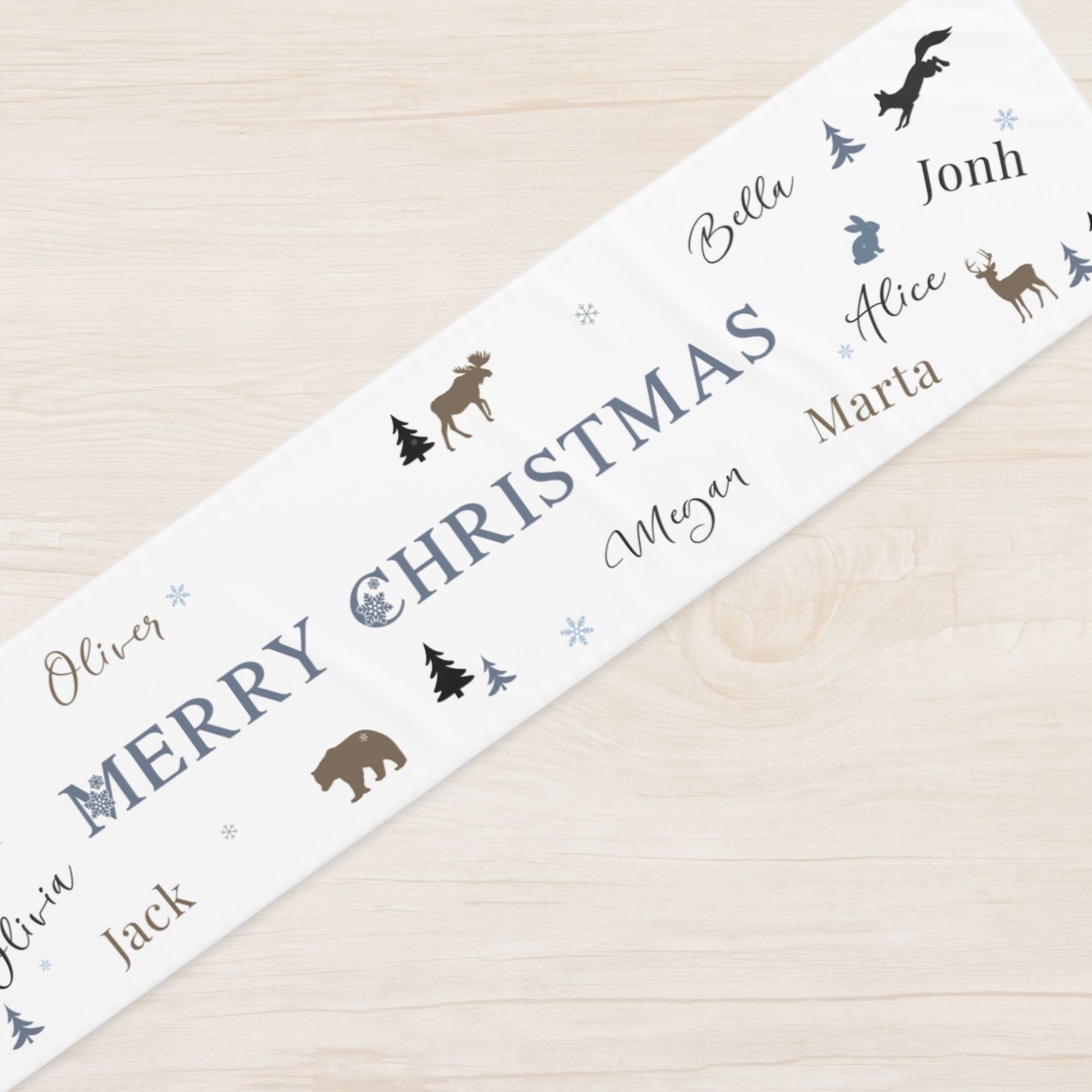 Personalized Christmas table runner with names and nature-themed illustrations on a wooden surface