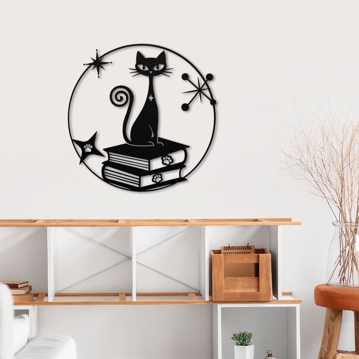 metal wall art of atomic cat on books with starburst designs in a modern room.