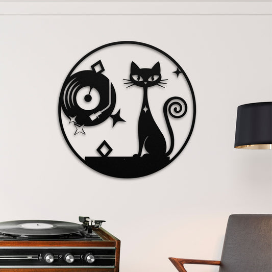 Decorative metal sign with a cat design on a white wall next to a record player.