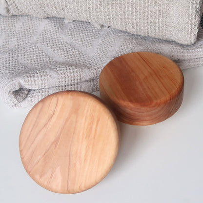 Front view of round alder sauna door knob, 80 mm diameter, smooth natural wood surface for glass or wooden doors.