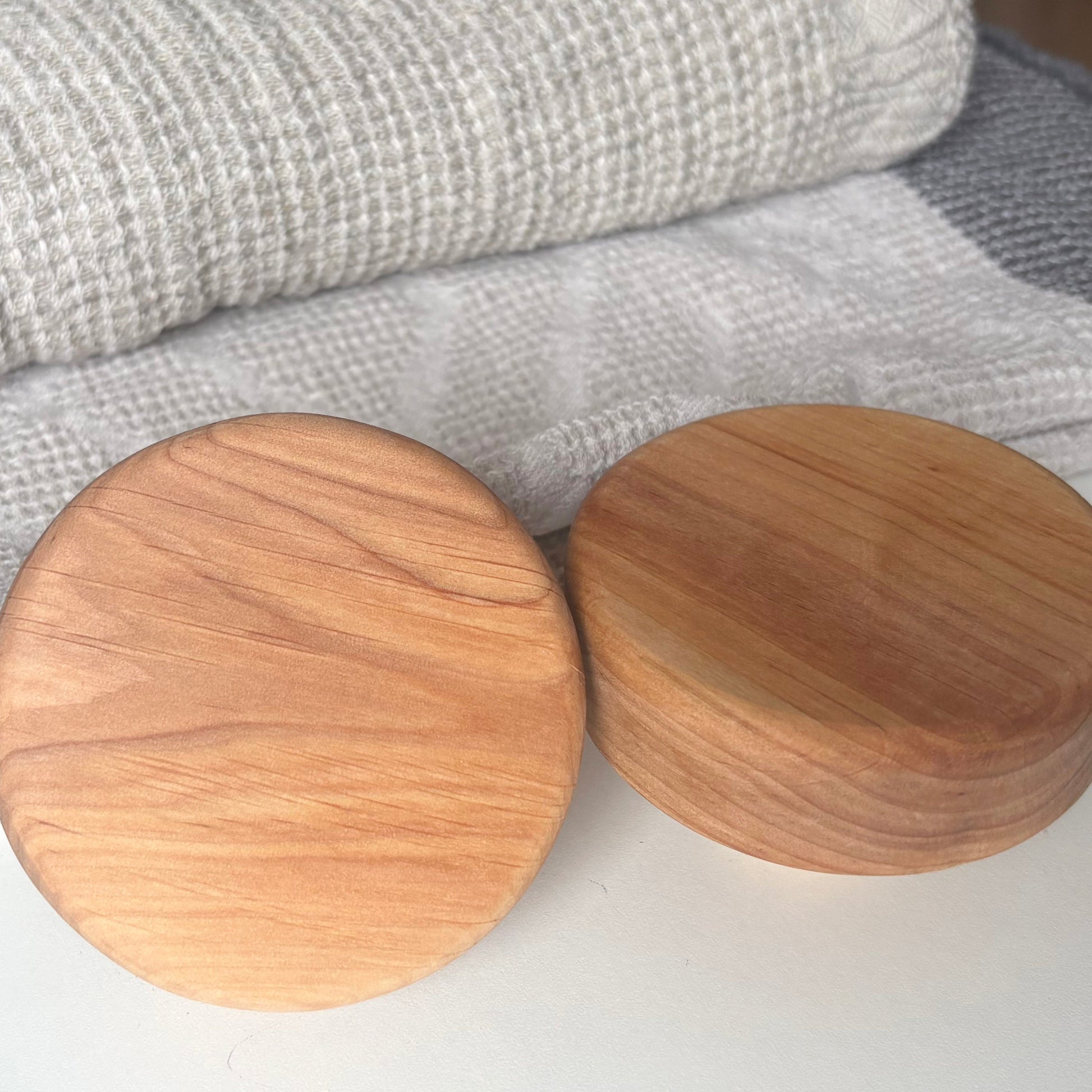 Close-up of alder wood sauna door handle showing natural grain pattern and warm reddish tone.