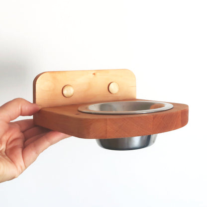 Hand holding a wall-mounted sauna aroma bowl holder