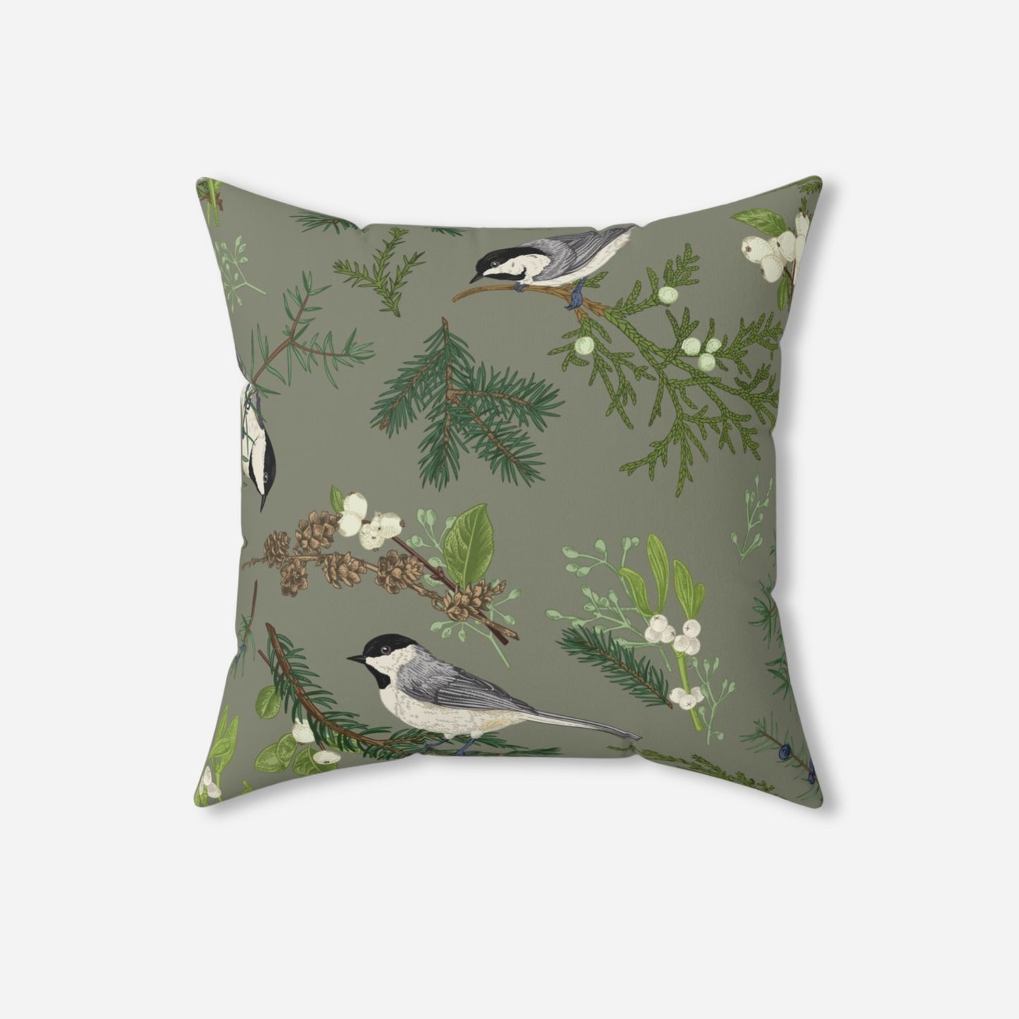 Decorative throw pillow with a nature-inspired design featuring chickadee birds perched on pine branches and sprigs of mistletoe on a muted green background.