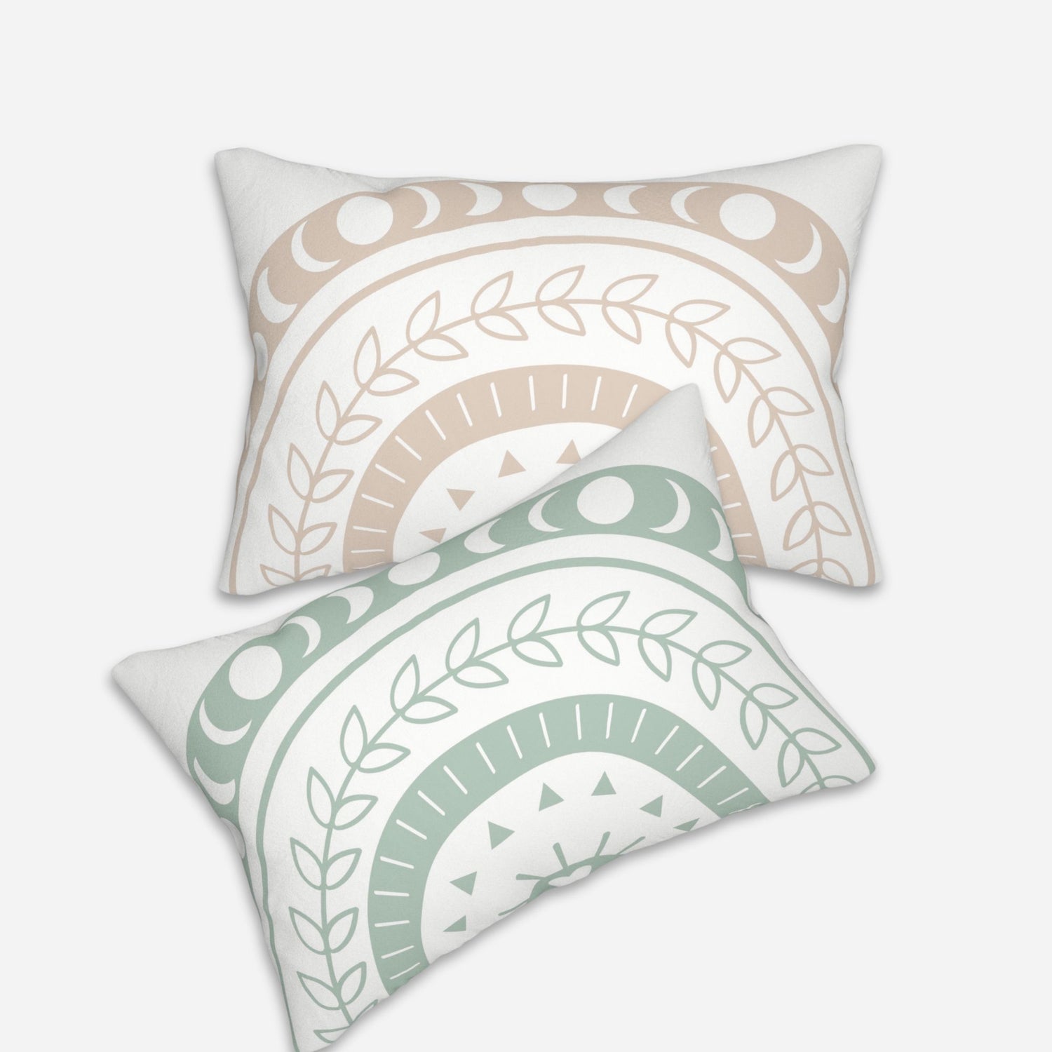 Pair of bohemian throw pillows, one in beige and the other in light green, adorned with crescent moons, leaves, and geometric patterns.