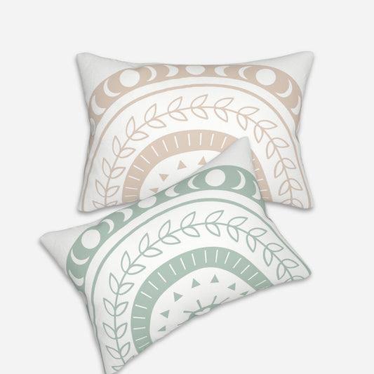 Pair of bohemian throw pillows, one in beige and the other in light green, adorned with crescent moons, leaves, and geometric patterns.