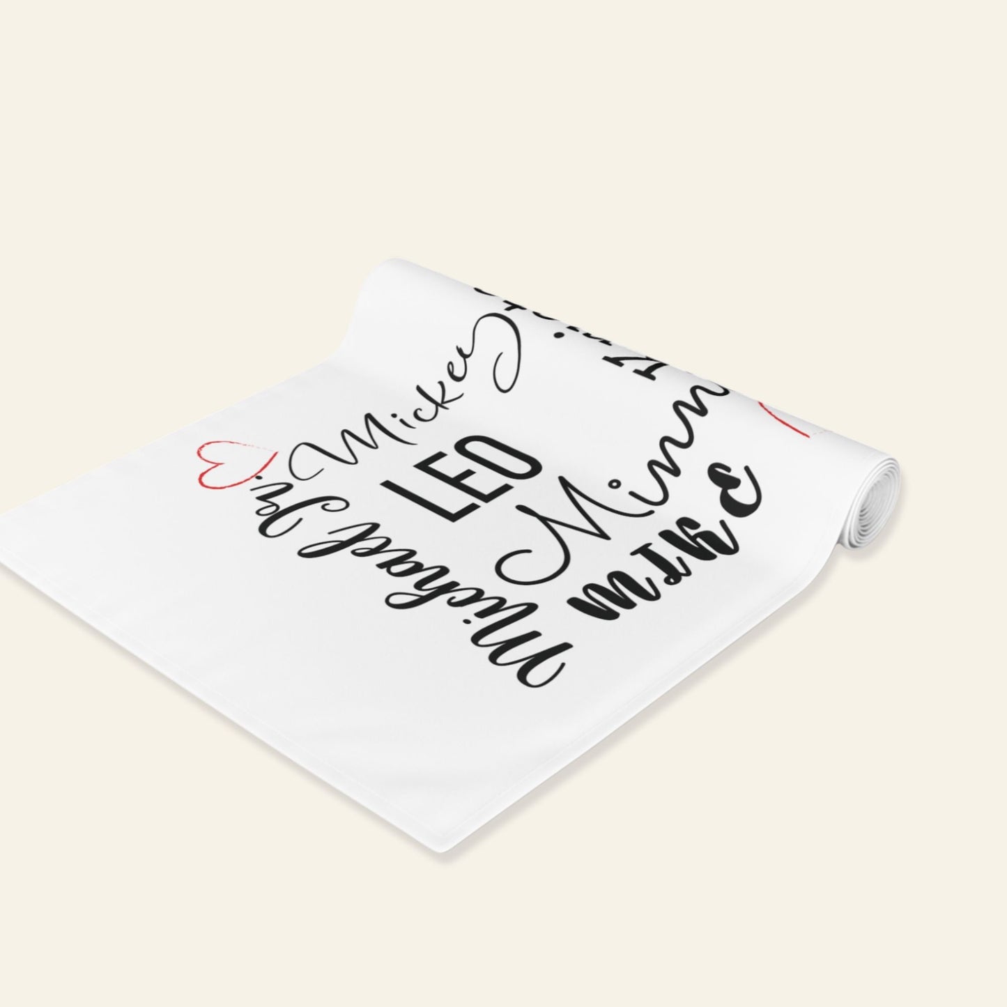 White table runner with black text and red heart on a beige background