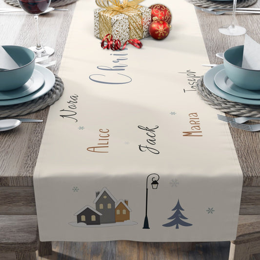 Table setting with a decorative table runner featuring names and Christmas-themed illustrations.