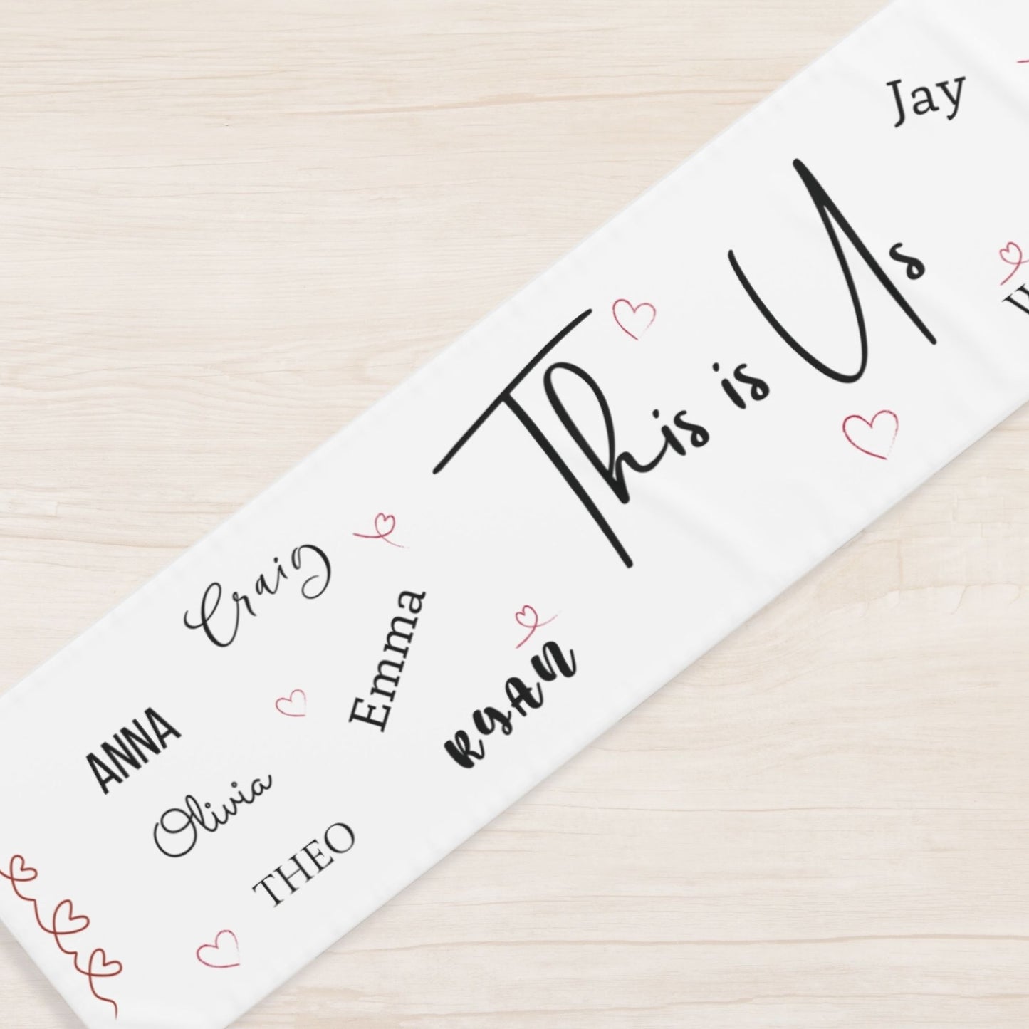 Personalized name runner with hearts on a wooden surface