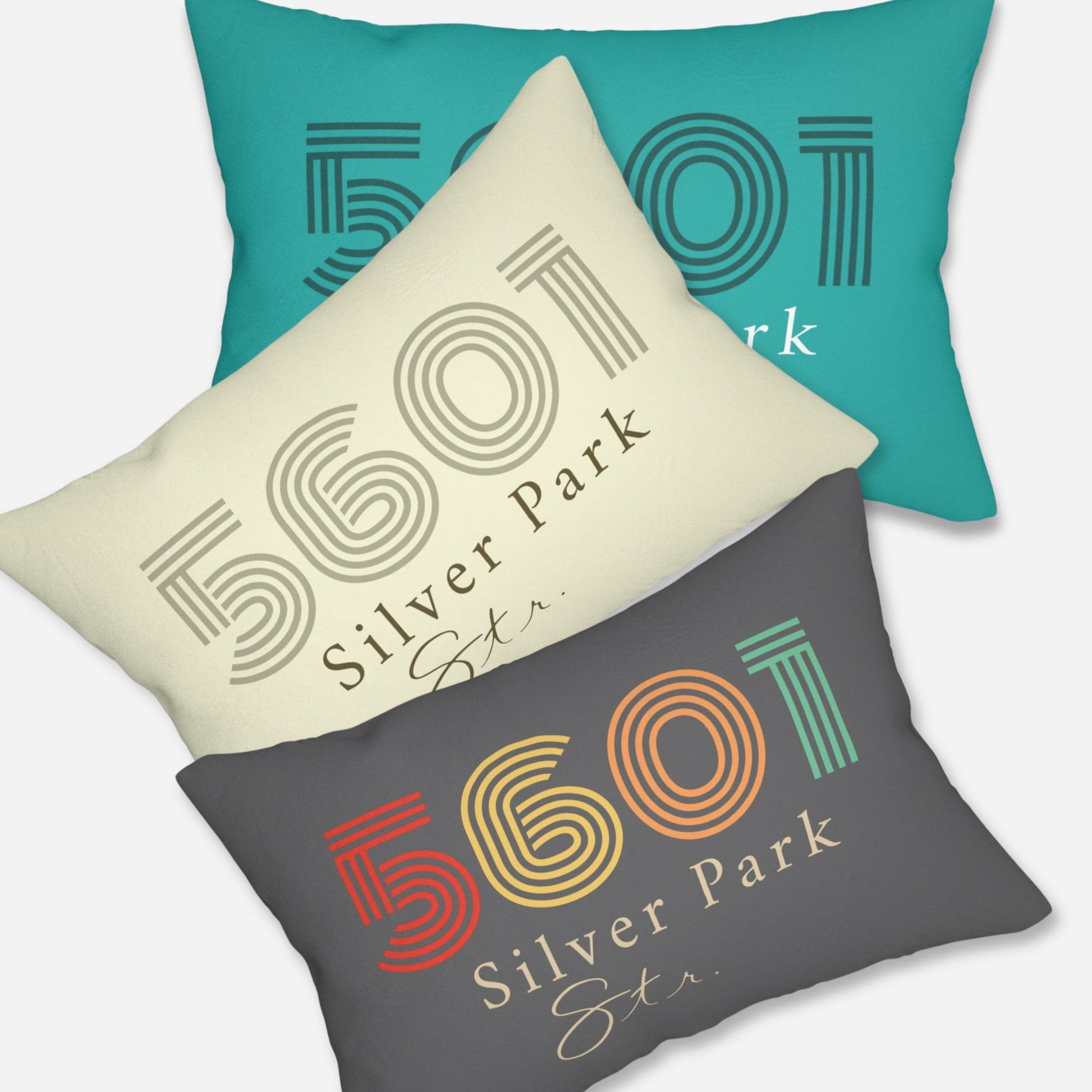 Set of three pillows designed with a vintage aesthetic, each displaying the address in unique color palettes: teal, off-white, and dark grey with striped numerals.