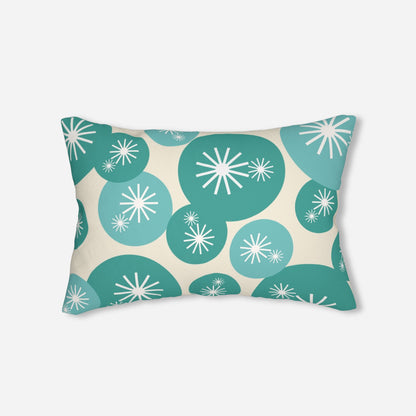 Pillow with a mid-century modern look, displaying teal and turquoise circular shapes with white starburst details on a light beige fabric