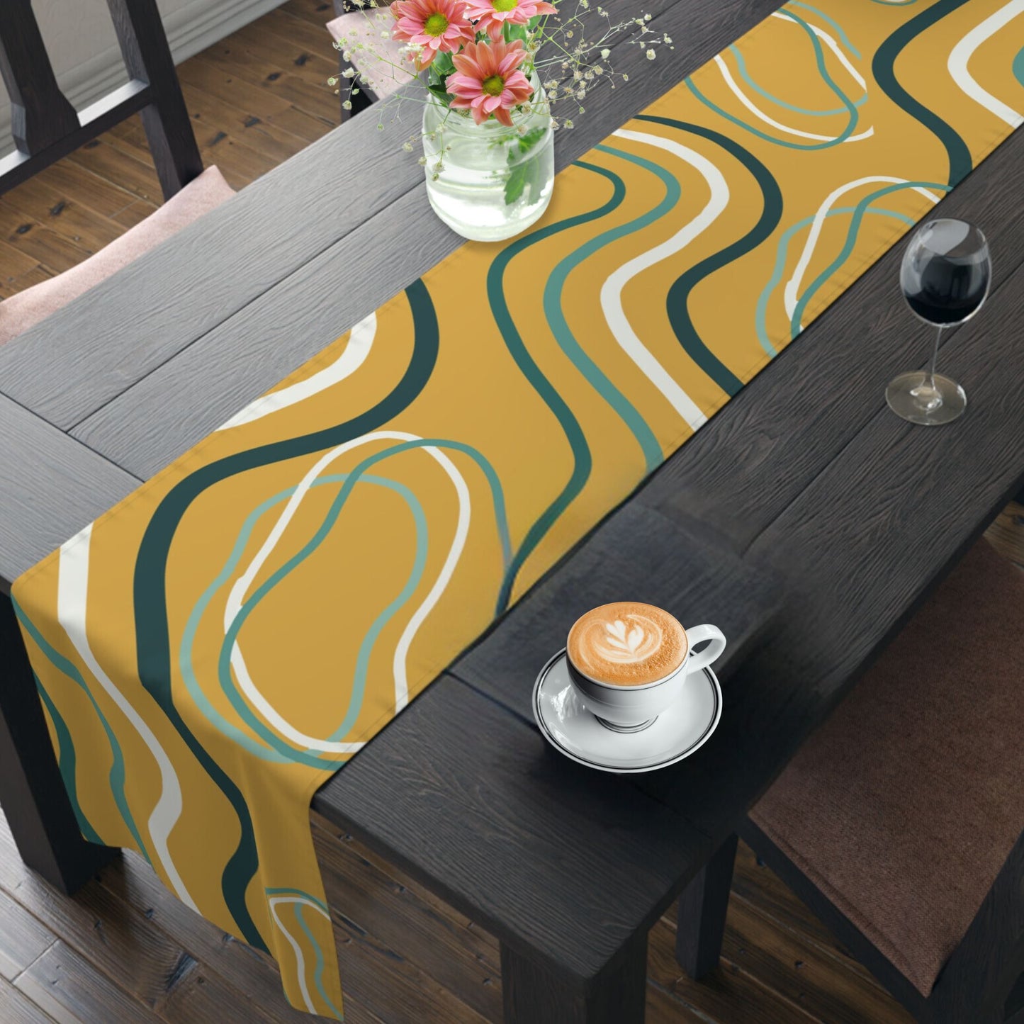 Dining table set with a modern table runner featuring wavy abstract patterns in mustard yellow, teal, and white.