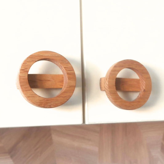 Wooden circular knobs on drawer with a white background