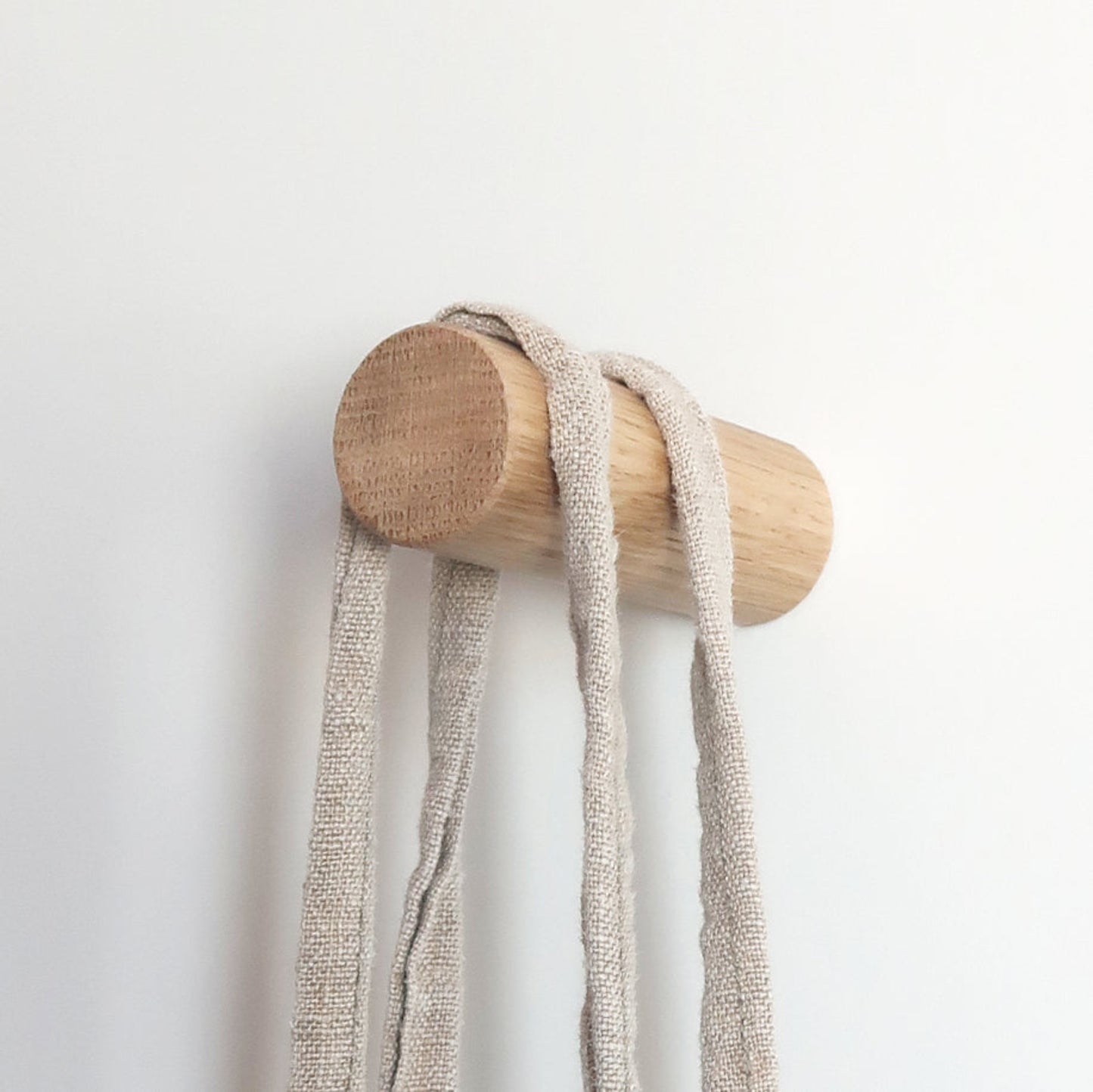 Solid wood wall hook holding a shoulder bag