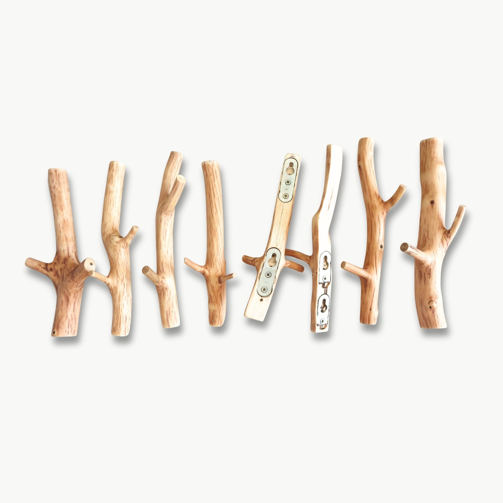 Set of wooden branch-shaped hooks on a white background