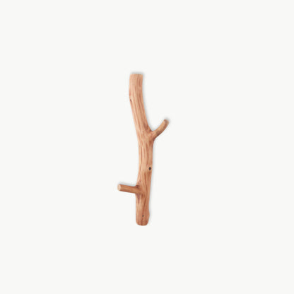 Natural oak wood wall hook with organic branch texture, minimalist home accessory.