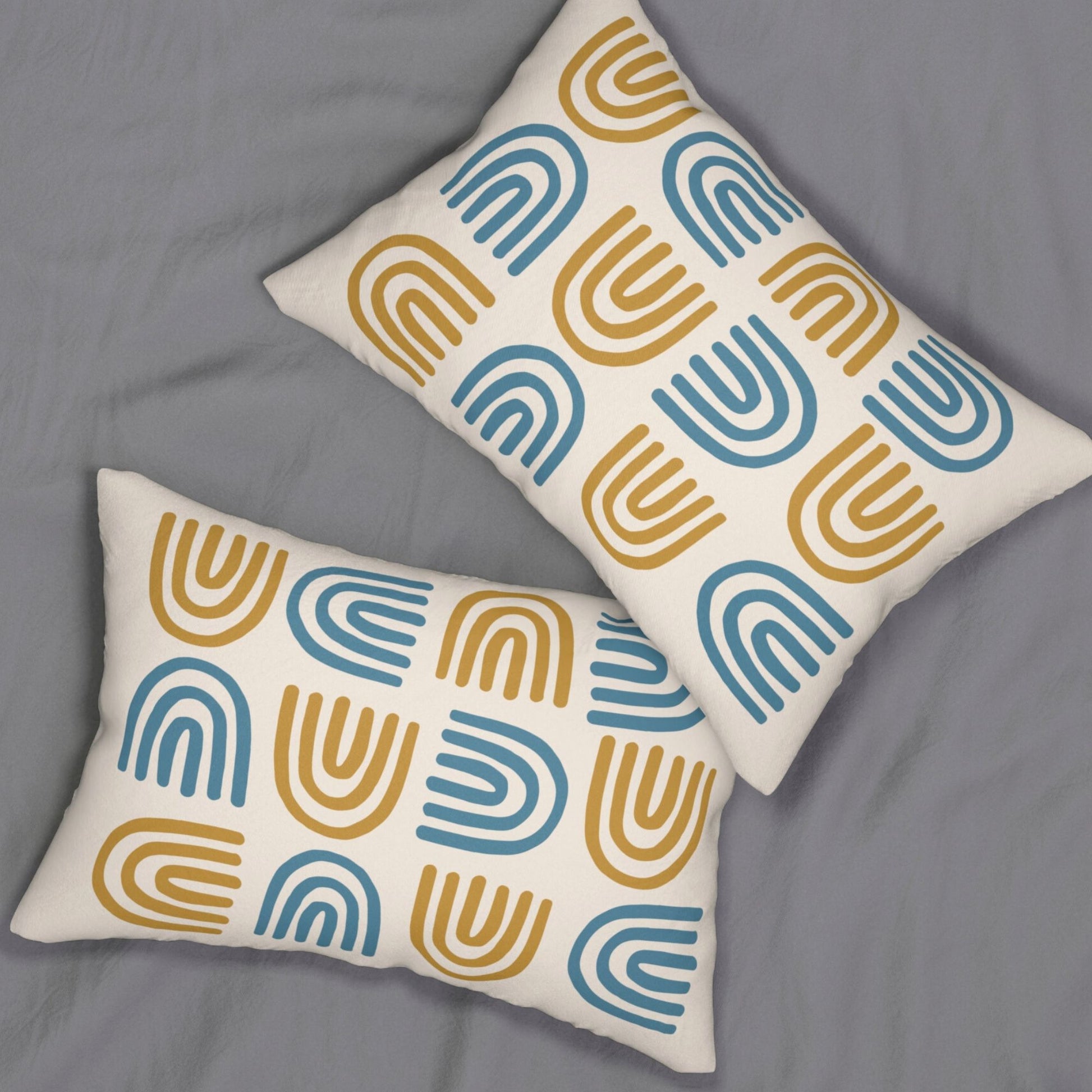 Bohemian style cushion with a repeating motif of mustard and blue semi-circles on a beige cover, resting on a gray 