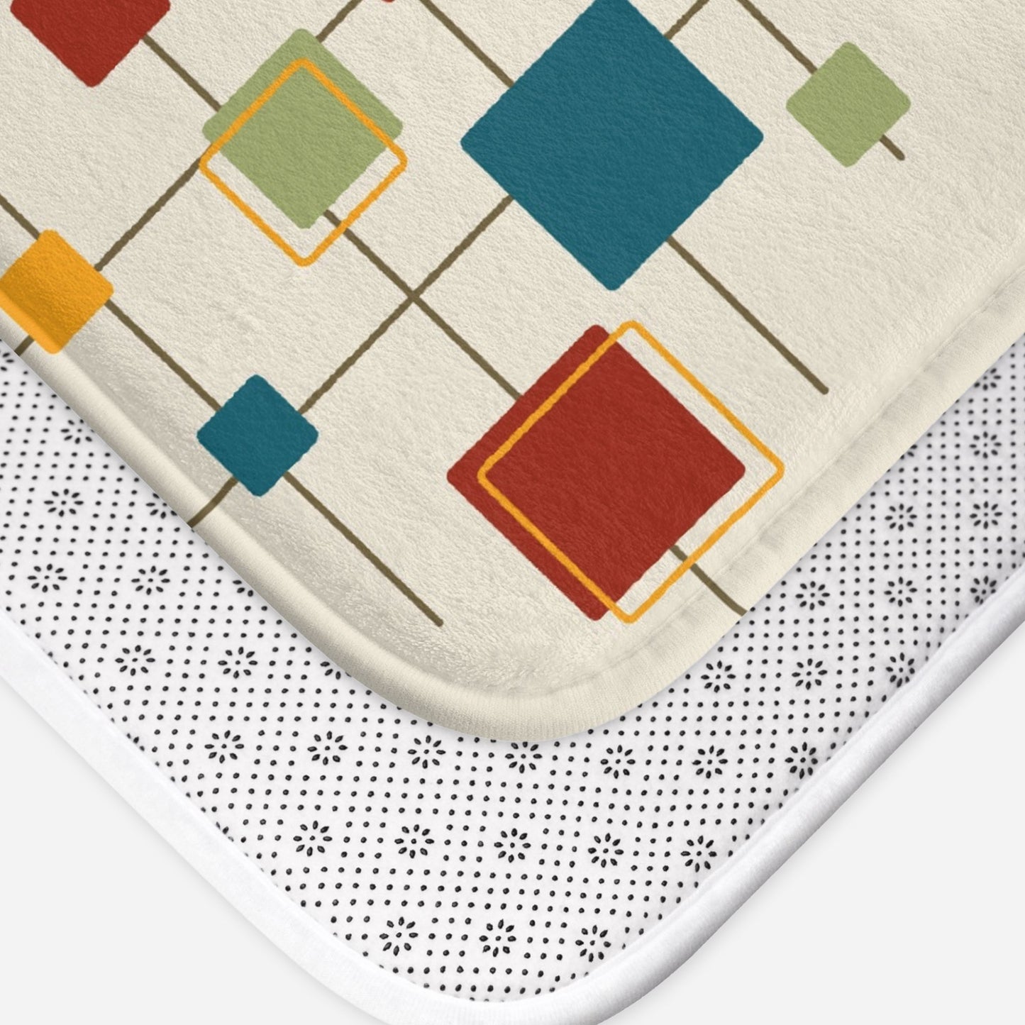 a cream-colored mat featuring a retro pattern of interconnected multicolored squares.