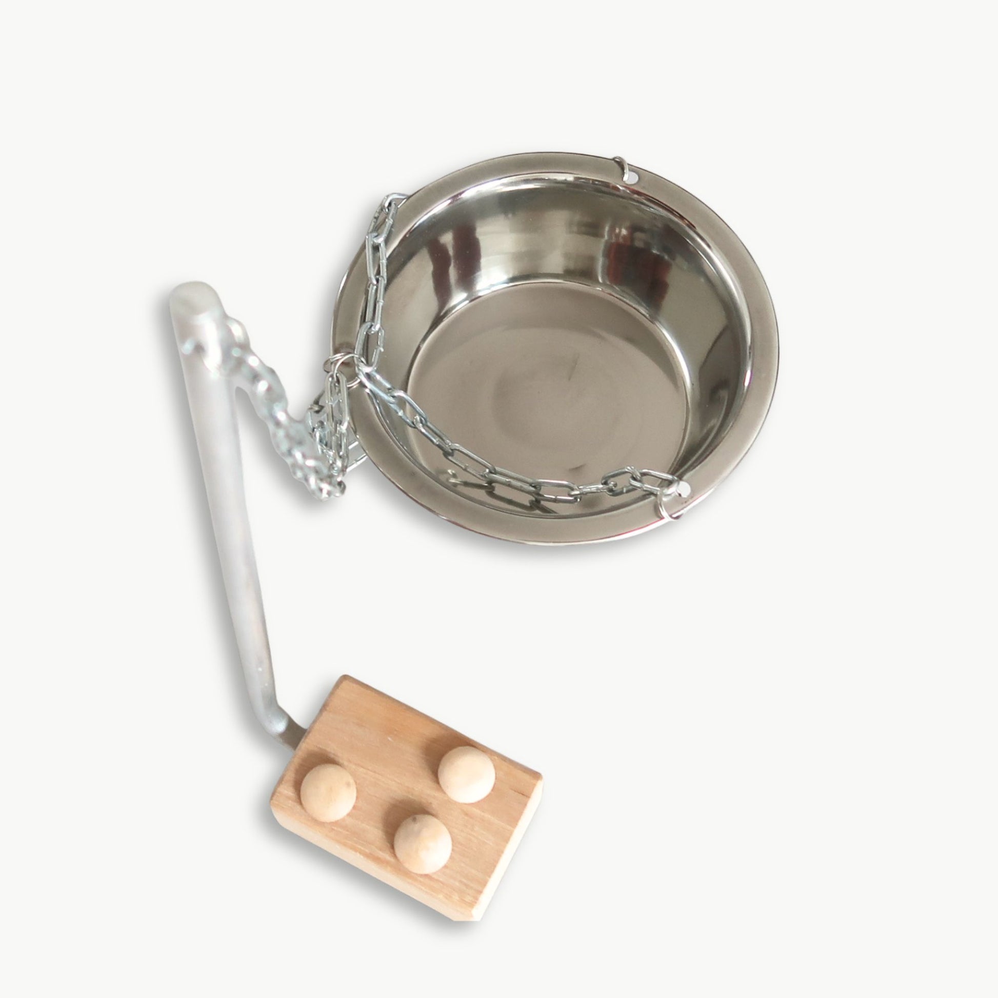 Metal bowl with chain and wooden block on a white background