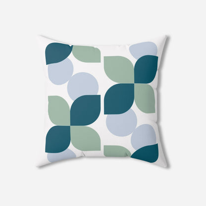 Contemporary throw pillow with a stylish pattern of teal, mint green, and light blue geometric shapes on a white fabric.