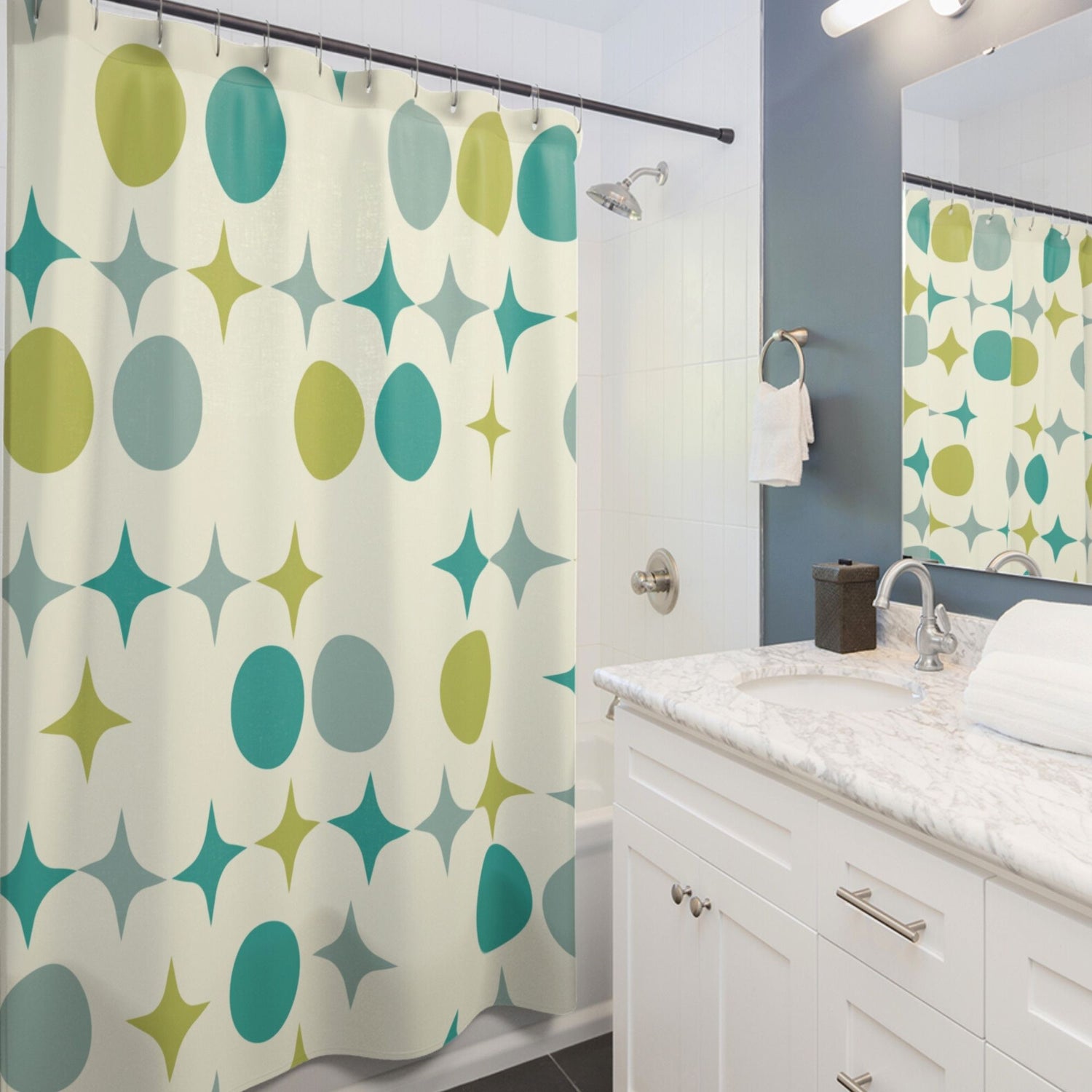 Retro-patterned shower curtain with teal and green ovals and starbursts in a modern white bathroom with marble countertop.