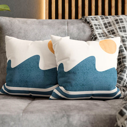 A cushion displaying a simple beach scene, with abstract blue waves at the base and a yellow sun 