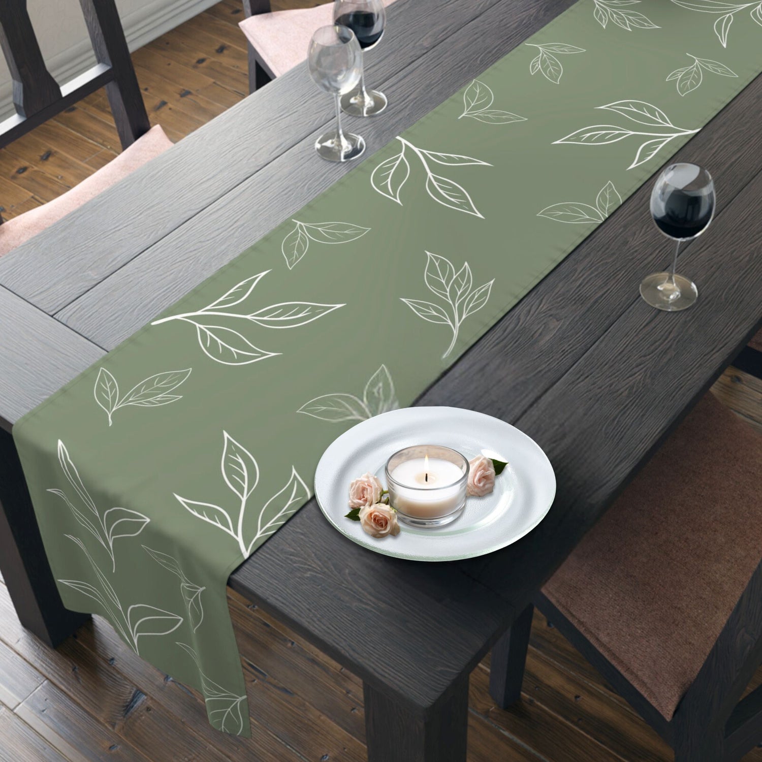  Dining table with a green runner decorated with a white leaf design.
