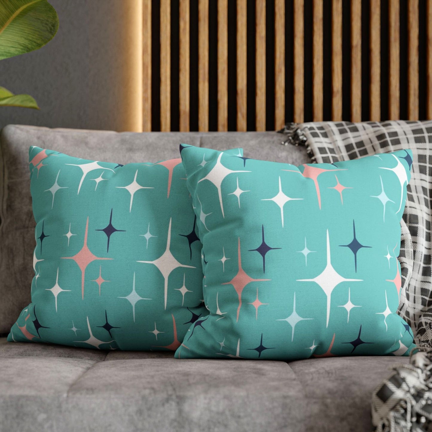 A pair of decorative pillows featuring a retro star design in shades of teal, pink, and navy