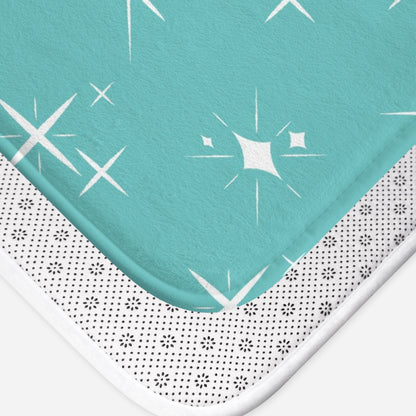 a teal bathroom mat with white starburst patterns 